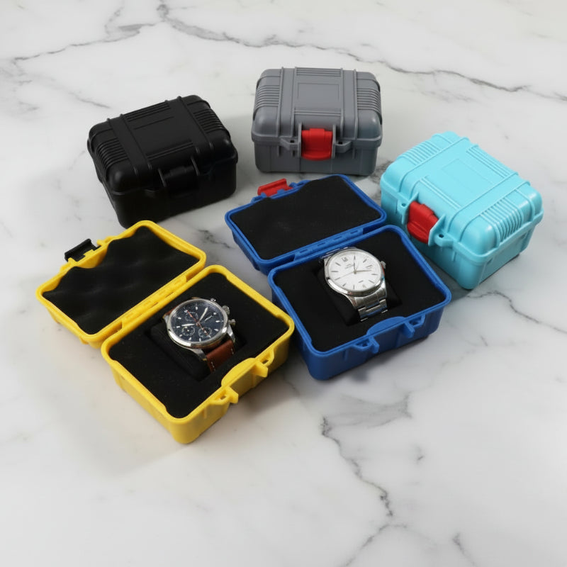 2 montres classes dans des boites de rangement étanche pour montres sur une table en marbre