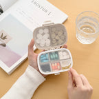 boite à pilule avec des médicaments sur une table avec une verre d'eau