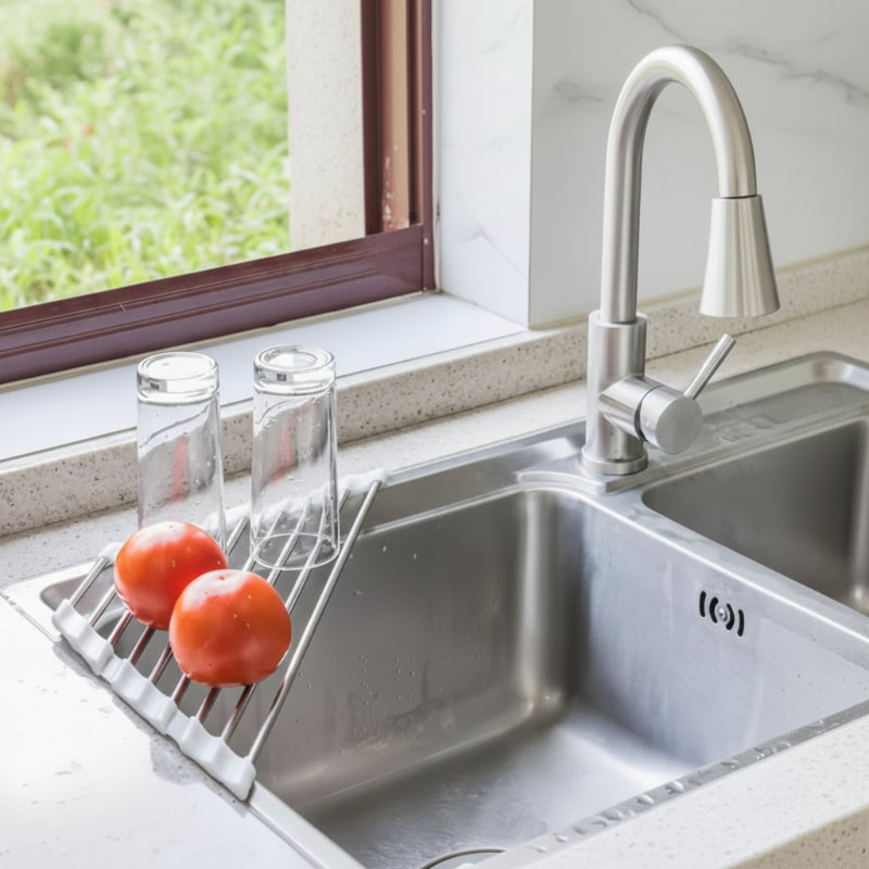 tomates et verres sur l'égouttoir organisateur d'évier pliable dans un évier de cuisine