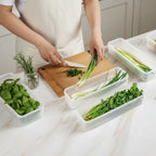 femme coupe persil puis le range dans les organisateur de frigo avec conservation hermétique