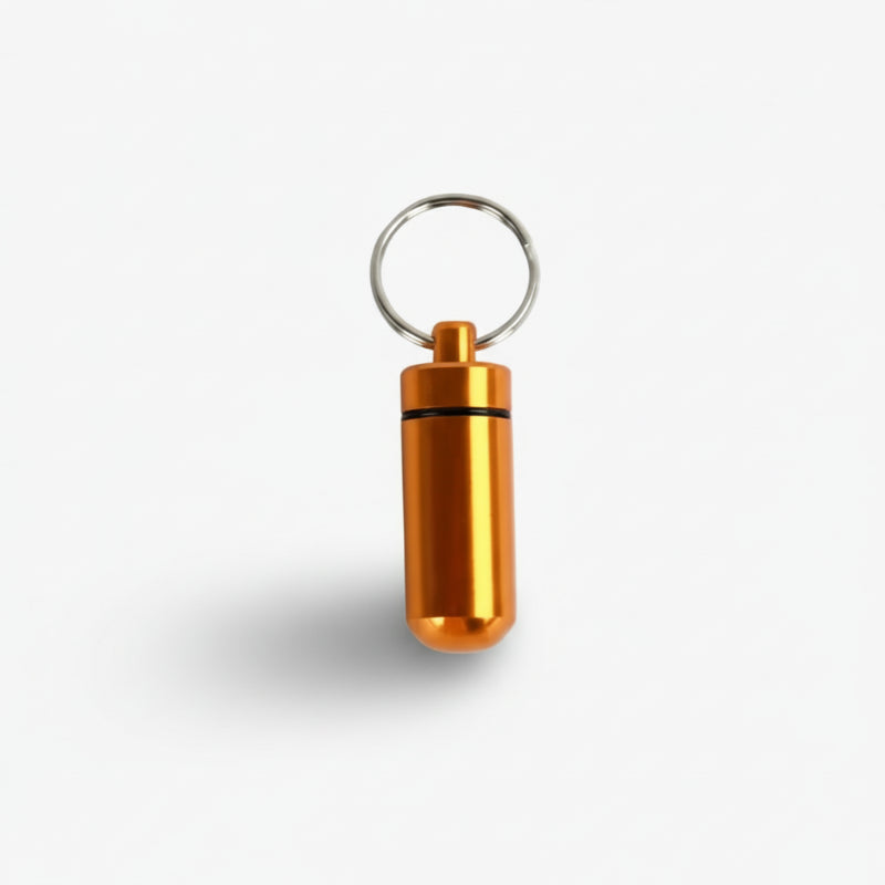 mini rangement de médicaments étanche de couleur orange sur fond blanc