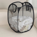 organisateur de linge pour salle de bain de couleur noir sur canapé