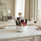 organisateur de maquillage rotatif de couleur blanc remplit de maquillage sur une coiffeuse