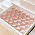 organisateur de tiroir en nid d’abeille de couleur rose dans une commode