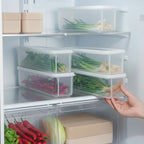 main qui place des organisateurs de frigo avec conservation hermétique dans un frigo