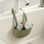 panier organisateur d’évier à suspendre avec égouttoir de couleur vert sur un évier de salle de bain blanc