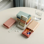 les différents pilulier de poche posés sur une table avec un verre d'eau