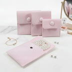 pochette organisateur de bijoux en velours de couleur rose sur une coiffeuse