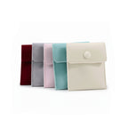 pochettes organisateur de bijoux en velours de différents coloris sur fond blanc