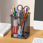 porte stylo noir carré avec plusieurs fournitures à l'intérieur sur un bureau