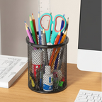 porte stylo noir rond avec plusieurs fournitures à l'intérieur sur un bureau