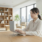 femme utilise le pc sur son support pliable portable en argent dans un salon